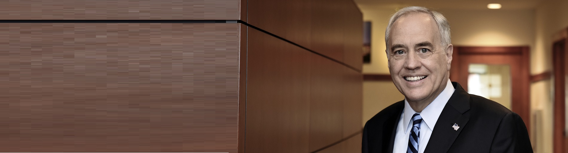 New York State Comptroller Thomas P. DiNapoli standing in an office hallway. 