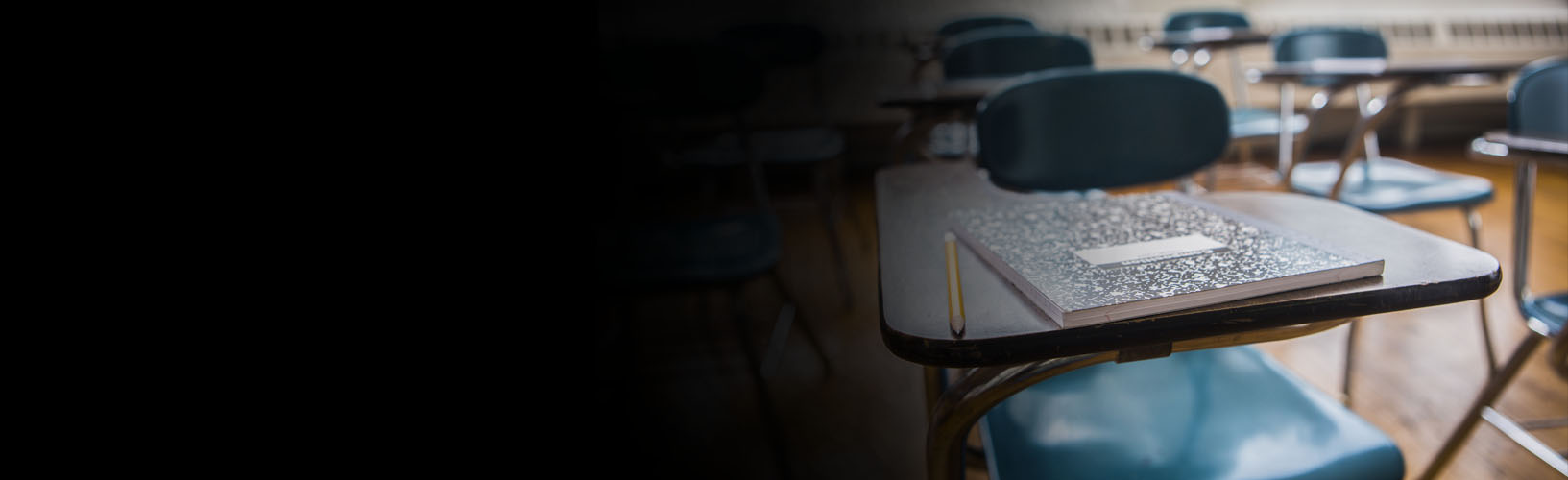 Picture of a desk with a notebook and pencil on top of the desk.