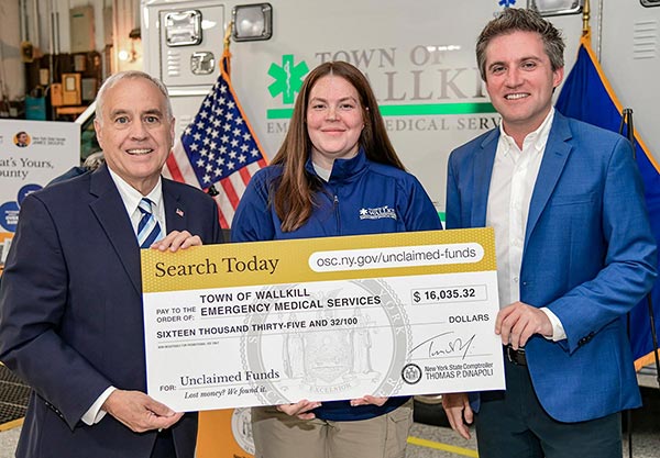 comptroller dinapoli hold a large check with town of wallkill new york emergency medical services members