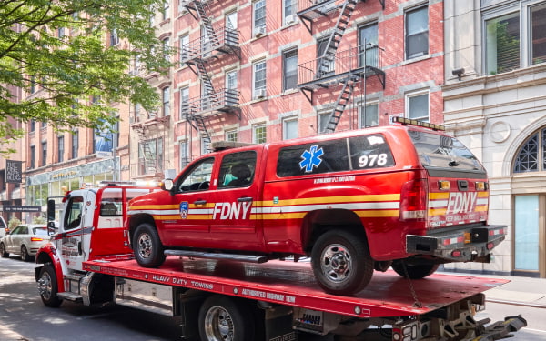 a new york city fire department vehicle sits on the bed of a tow truck