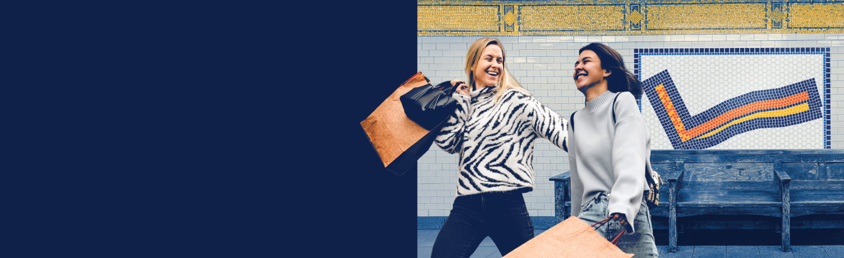 two women in a subway station holding shopping bags