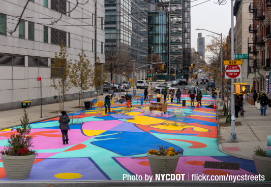 Brightly painted street with people walking on it NYC