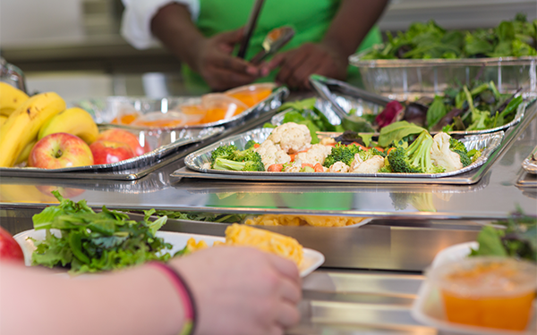 student receives a selection of healthy foods in school cafeteria line