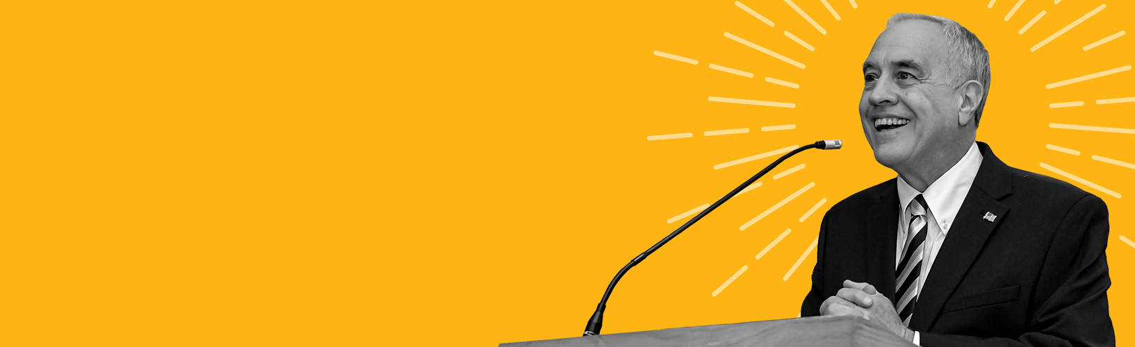 state comptroller dinapoli standing at a podium speaking with rays of sunshine surrounding him