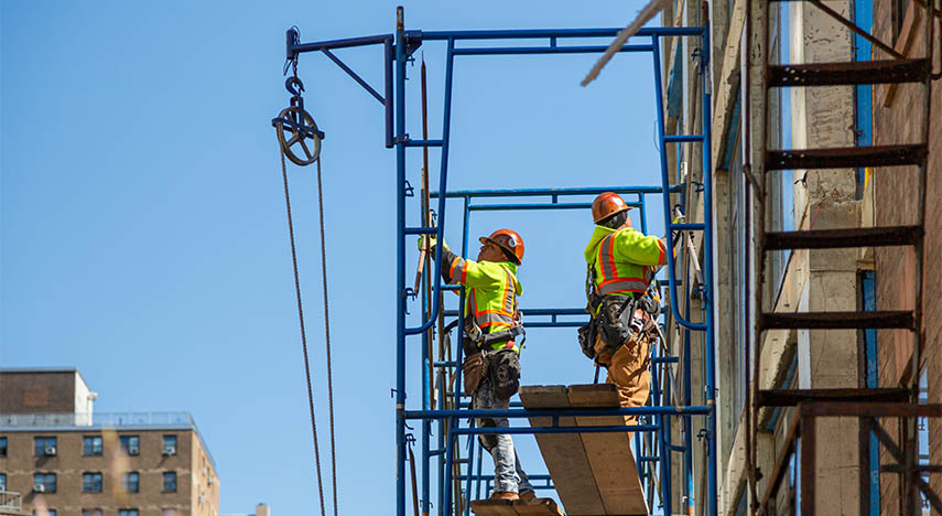 construction workers standing on scaffolding