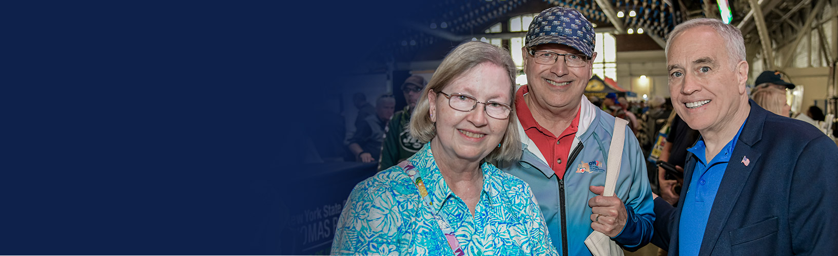 Comptroller Thomas P. DiNapoli posing for a photo with two adults