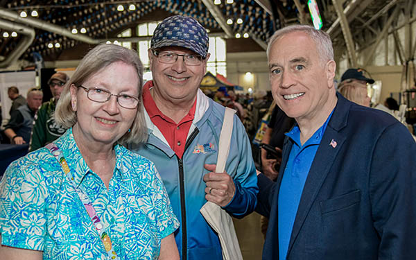 Comptroller Thomas P. DiNapoli posing for a photo with two adults