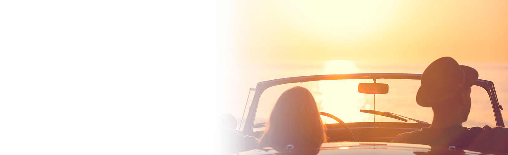 couple looking at sunset from convertible