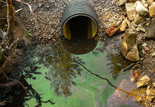 toxic waste water flowing out of sewer pipe