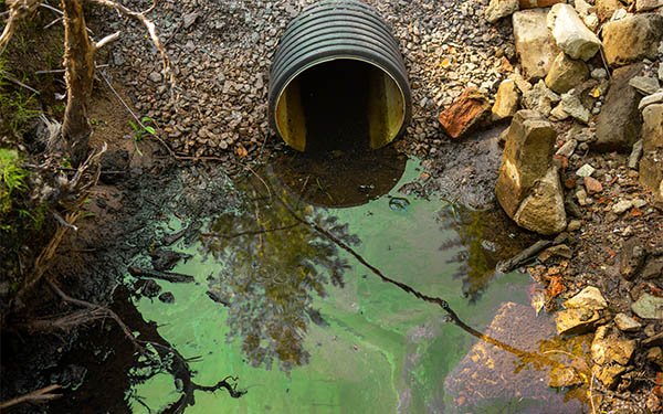 toxic waste water flowing out of sewer pipe