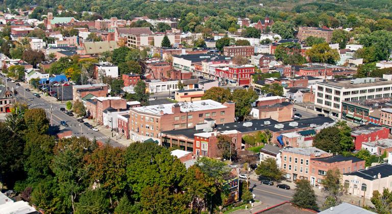 Aerial shot of Albany, New York on a sunny day in early Fall, flying over Washington Park and looking towards red brick buildings in Central Avenue and West Hill neighborhoods.