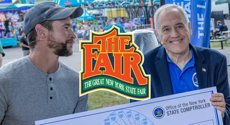 Comptroller DiNapoli and a member of the Tiny Home for Good organization holding a large check at the New York State Fair