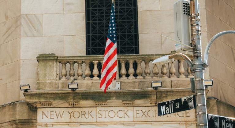 an american flag flying above the new york stock exchange building