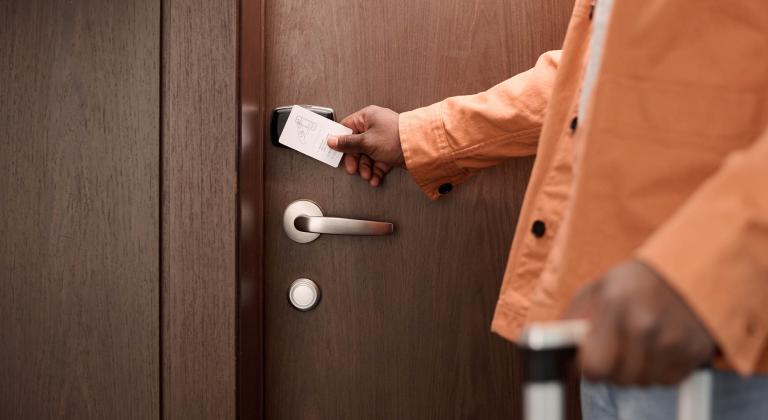 person swiping key card to enter hotel room