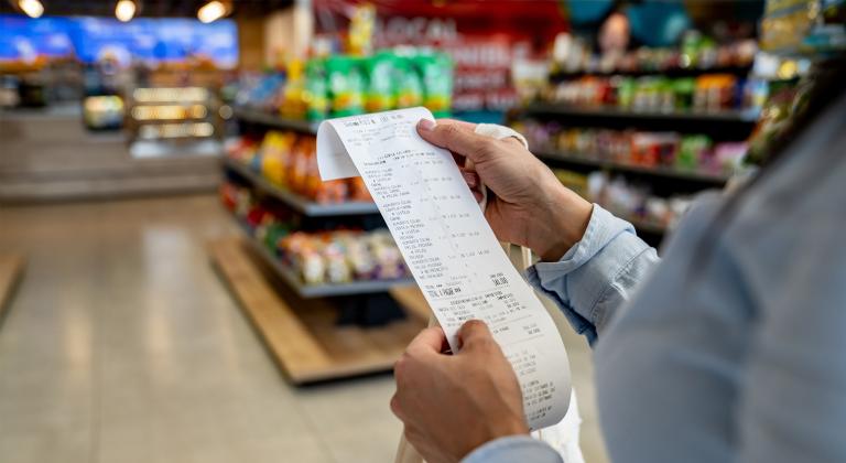 person shopping at a convenience store and checking their receipt