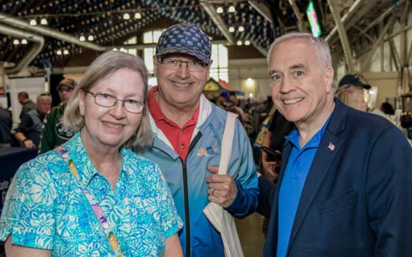 state comptroller dinapoli standing with two new york state retirees at the new york state fair