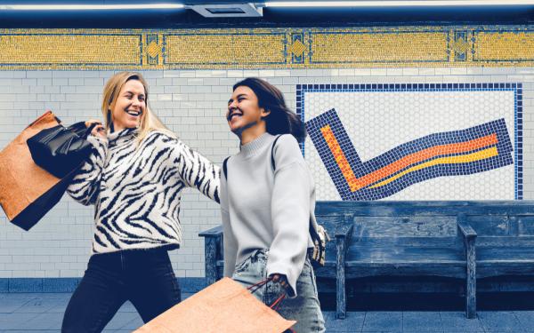two women in a subway station holding shopping bags