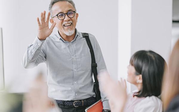 older office worker saying goodbye to coworkers