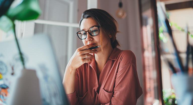 Adult woman planning and looking at laptop