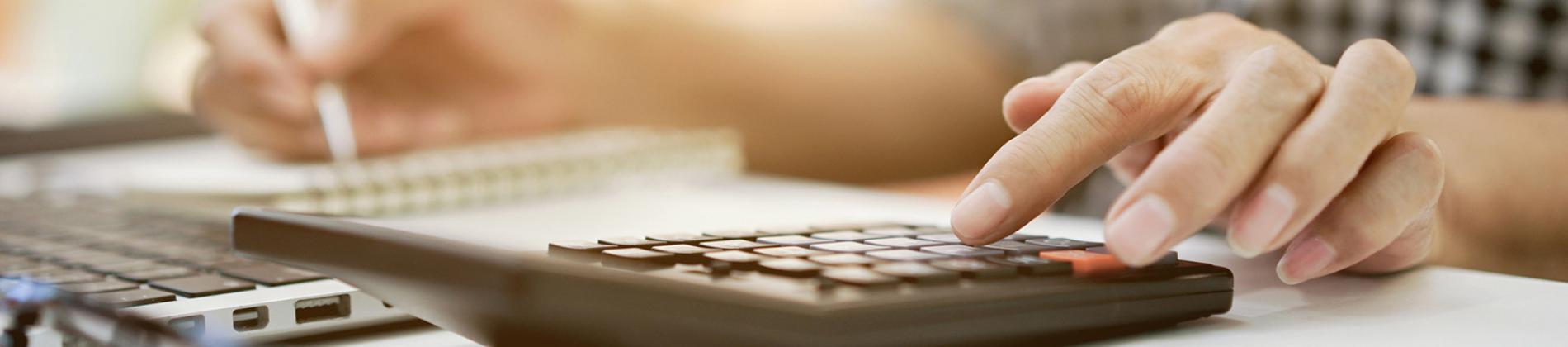 Hand using a calculator on a desk