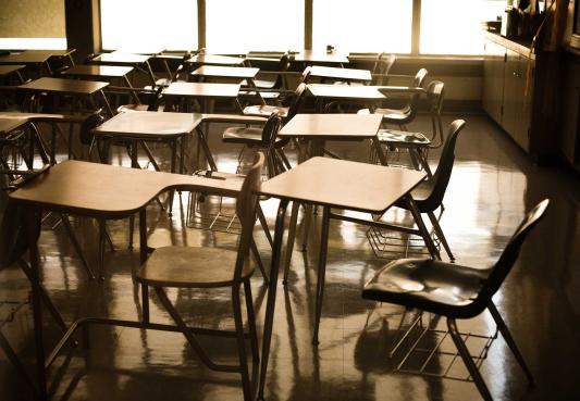natural light casting through a large window in an empty grade school classroom