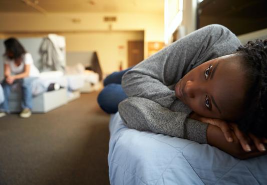 person lying on bed in homeless shelter