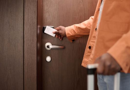 person swiping key card to enter hotel room