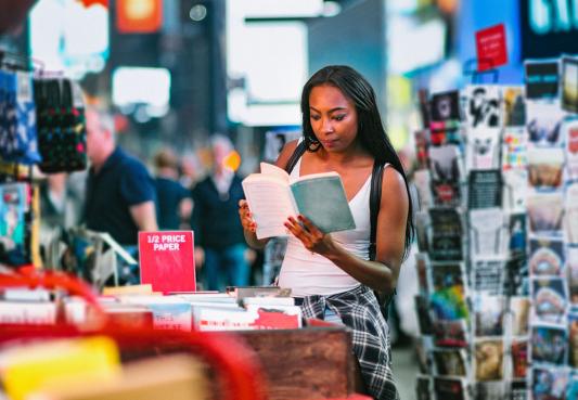 Consumer reading an open book in a retail store.