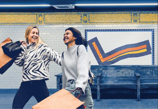two women in a subway station holding shopping bags