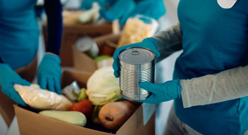 volunteers packing donated food in cardboard boxes