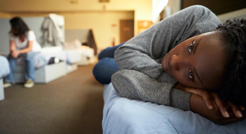 person lying on bed in homeless shelter