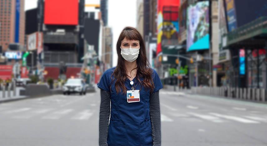 Health worker with mask on standing in Times Square