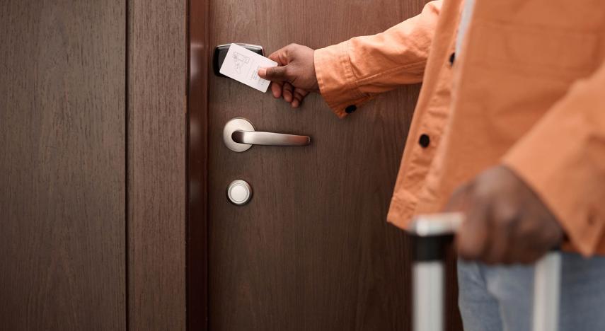 person swiping key card to enter hotel room