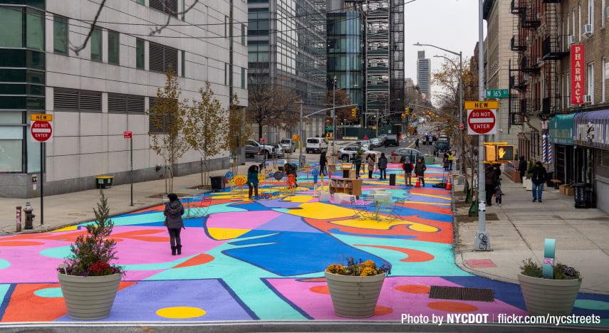 Brightly painted street with people walking on it NYC