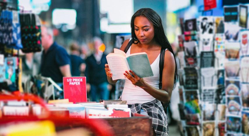 Consumer reading an open book in a retail store.