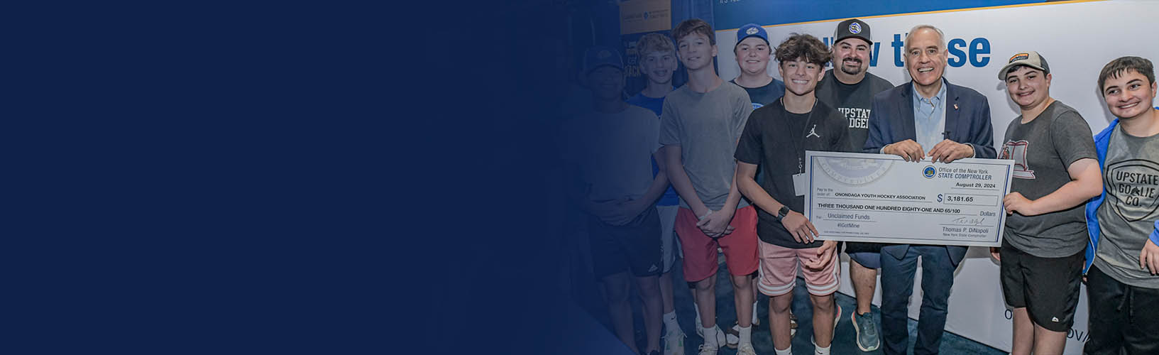 new york state comptroller thomas p. dinapoli and athletes from the onondaga youth hockey association at the new york state fair