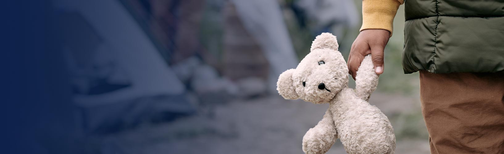Homeless child holding white teddy bear